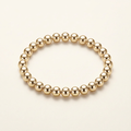8 mm gold-plated bead bracelet on a warm ivory background
