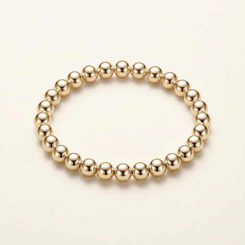 8 mm gold-plated bead bracelet on a warm ivory background