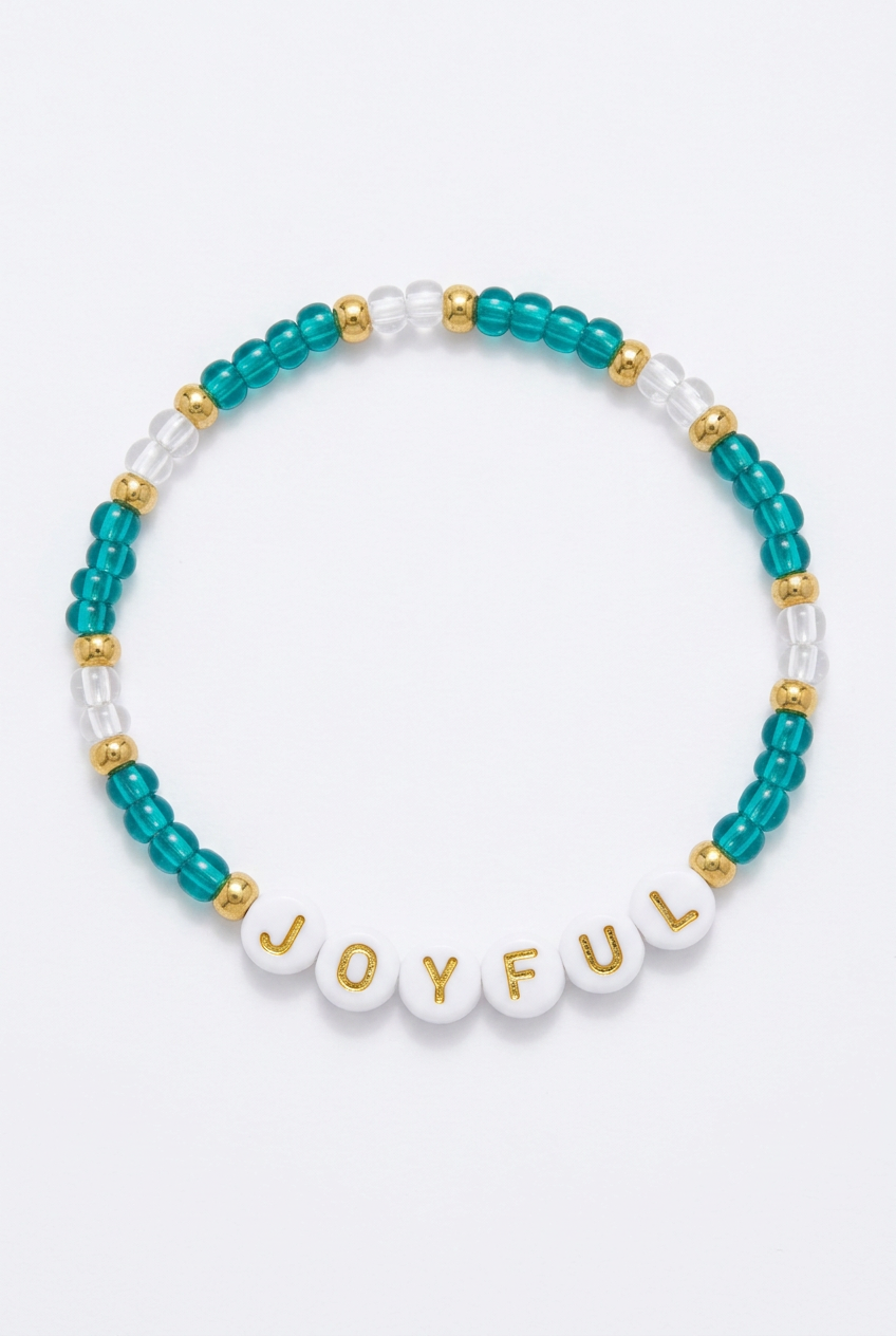 Teal JOYFUL beaded bracelet with gold-colored spacers on a soft-white background