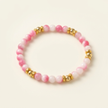 Handmade tourmaline jade bracelet with gold-plated spacers on a warm ivory background