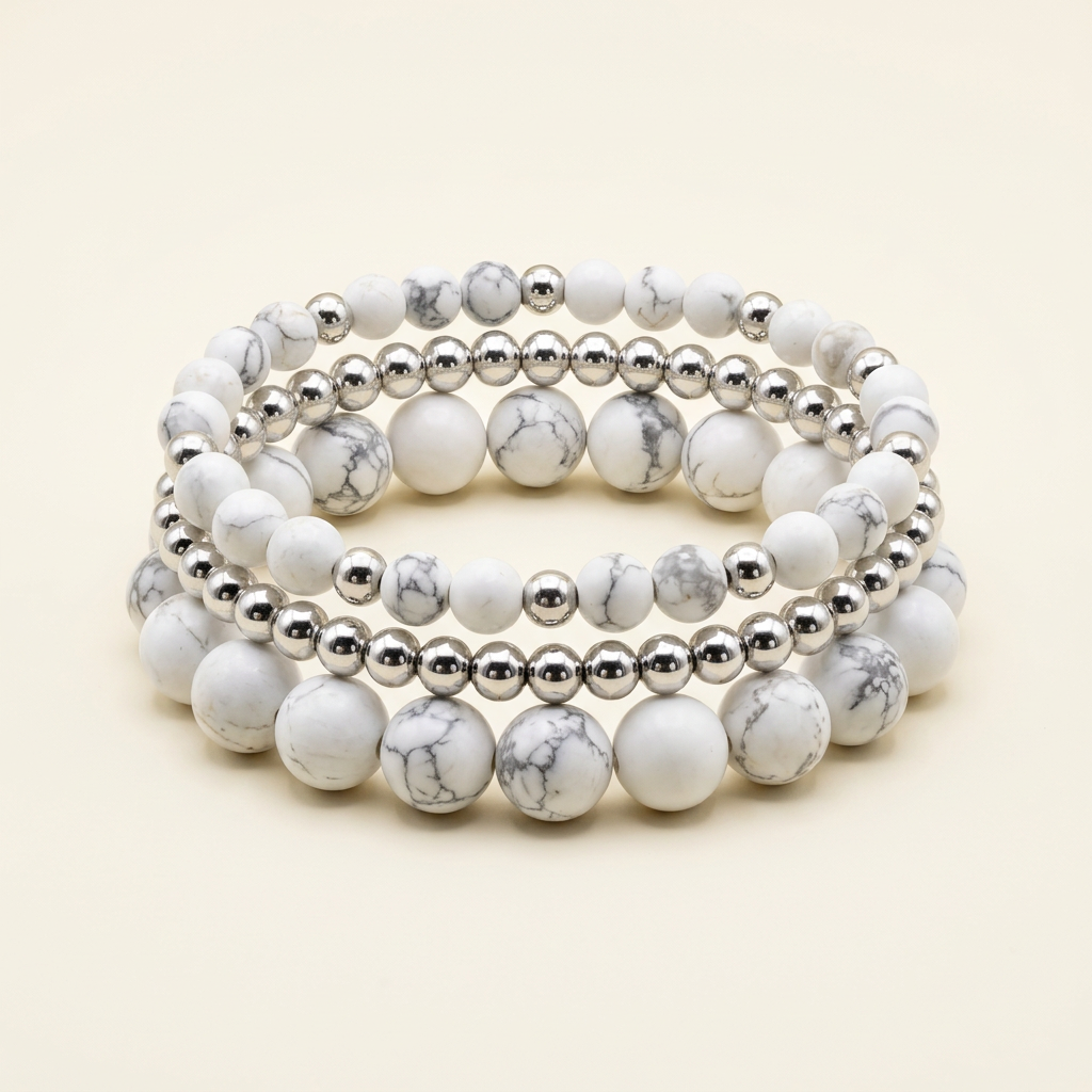 Handmade howlite and silver-plated three-bracelet stack on a warm ivory background