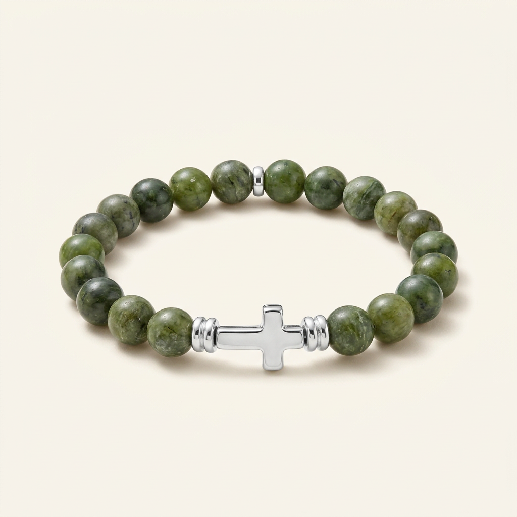 Canadian jade bracelet with silver-tone spacers and a silver-plated cross on a warm-white background