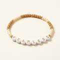 Fearless bracelet with tan and cream beads and gold-tone accents on an ivory background