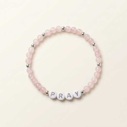 Pink rose quartz PRAY bracelet with silver-colored accents arranged in a circle on ivory