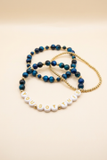 Blue tiger eye three-bracelet set with YOU GOT THIS letter beads and a gold-plated bracelet on ivory