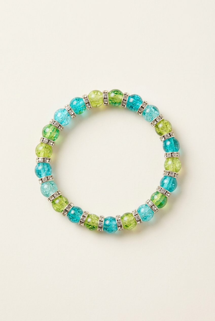 Blue and green glass bead bracelet with shimmering spacers on an off-white background