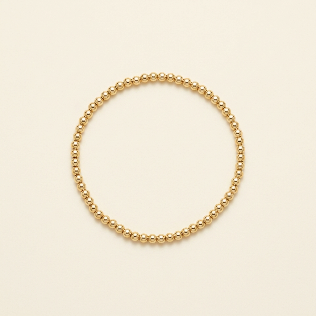 3 mm gold-plated bead bracelet on a warm ivory background