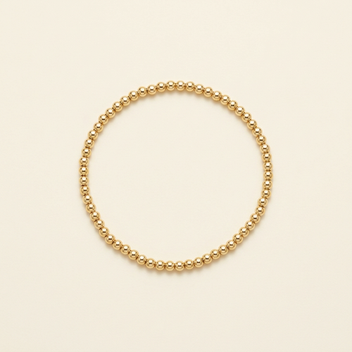 3 mm gold-plated bead bracelet on a warm ivory background