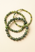 Three Canadian jade bracelets in different bead sizes on a warm ivory background