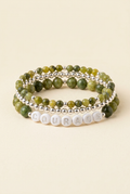 Handmade Canadian jade COURAGE three-bracelet stack with silver-plated details on a warm ivory background