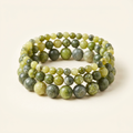 Handmade Canadian jade three-bracelet stack on a warm ivory background