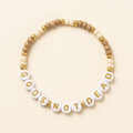 Tan and cream God’s Not Dead seed bead bracelet with gold-colored accents on an ivory background