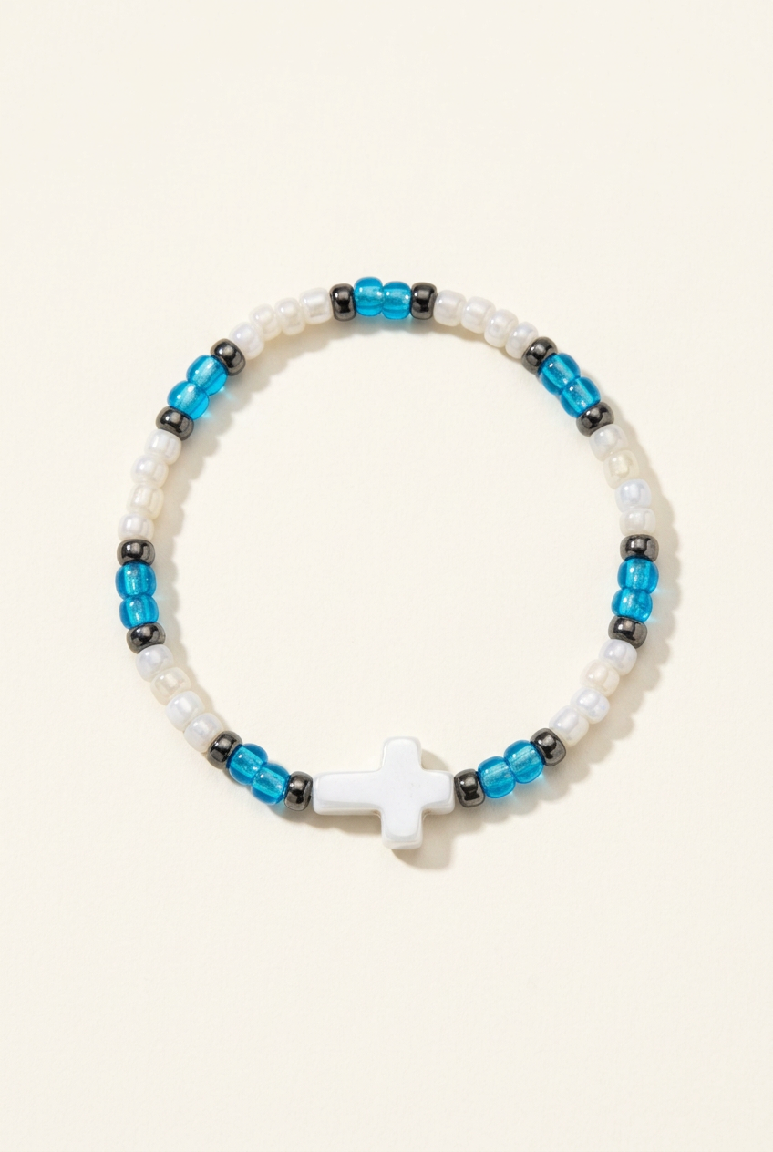 White and bright blue seed bead bracelet with a silver cross on an ivory background
