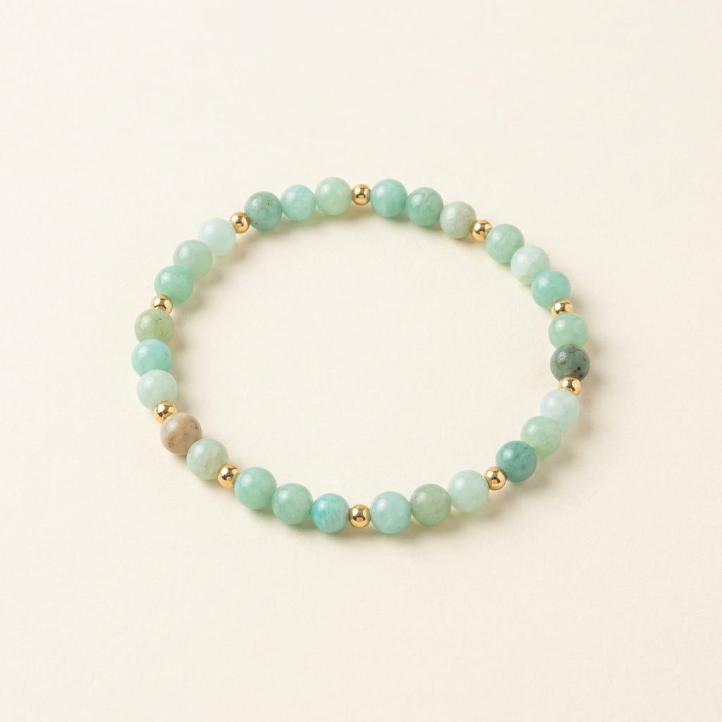 Handmade amazonite bracelet with gold-plated spacers on a warm ivory background