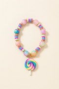 Pastel beaded children's bracelet with rainbow lollipop charm on a warm ivory background