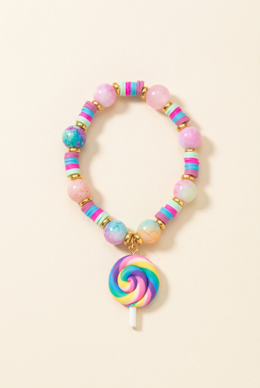 Pastel beaded children's bracelet with rainbow lollipop charm on a warm ivory background