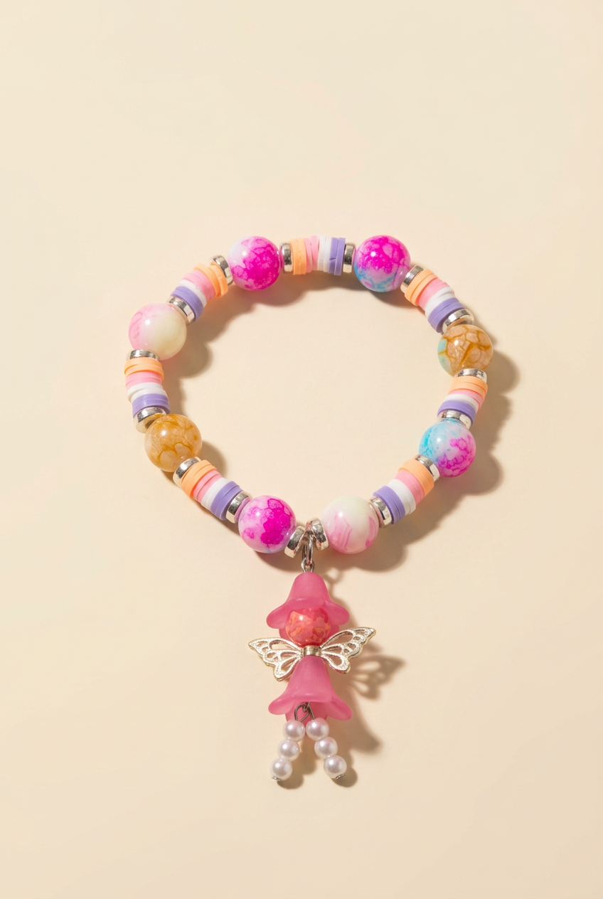 Colorful children's beaded bracelet with a dangling fairy charm on a warm ivory background