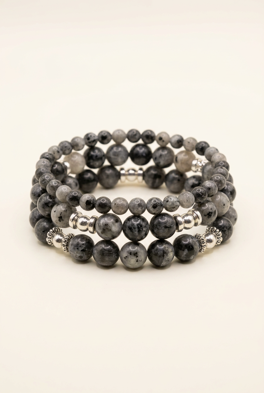 Handmade three-bracelet stack with silver-plated accents on a warm ivory background