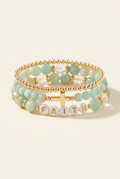 Handmade smooth amazonite faith three-bracelet stack with gold details on a warm ivory background