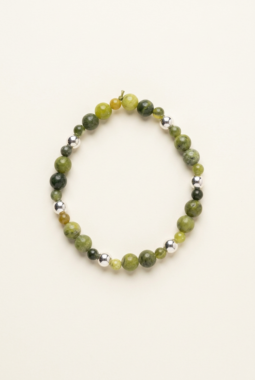 Handmade Canadian Jade bracelet with silver-plated beads on a warm ivory background