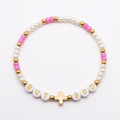 Pink-purple and white seed bead bracelet with BUT GOD letter beads and a gold-colored cross on a white background