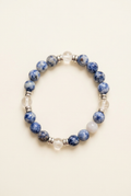 Handmade blue spot Jasper and clear quartz bracelet with silver-colored spacers on an ivory background