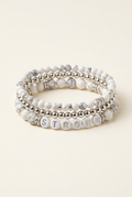 Handmade STRONG howlite and silver-plated three-bracelet stack on a warm ivory background